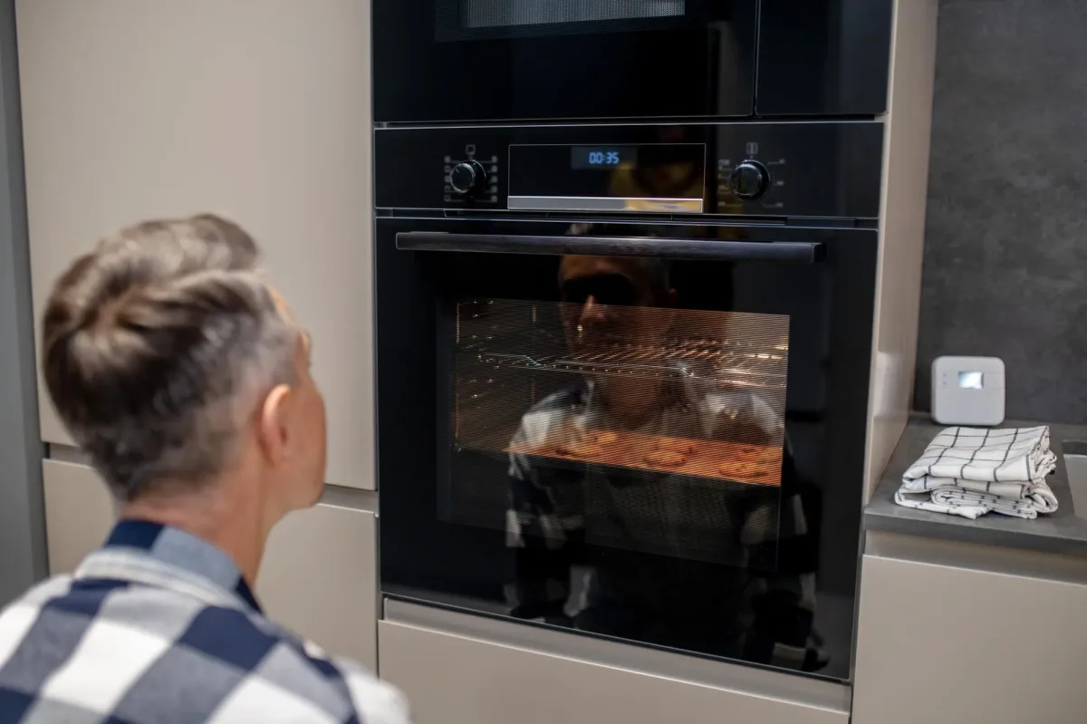 Backofen Reparatur Wien - Kunde prüft Anzeige am Backofen