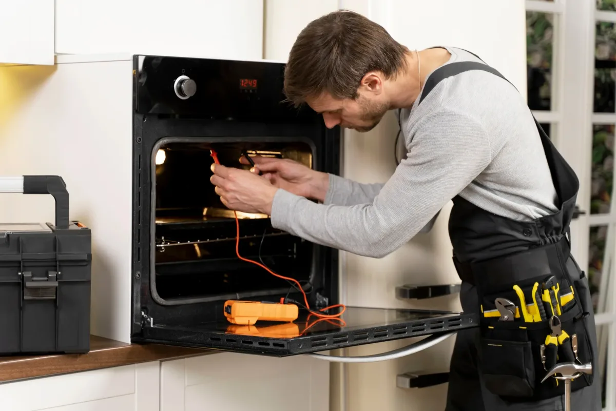 Backofen Reparatur Wien - Techniker repariert Backofen mit Messgerät
